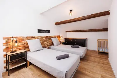 two beds in a room with wooden floors at Duplex Factory II Hyper Centre in Salon-de-Provence