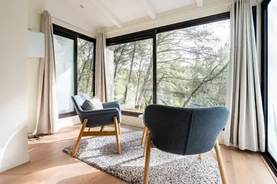 a living room with two chairs and a large window at Le Dandy in Aix-en-Provence