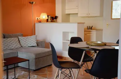 a living room with a couch and a table and chairs at Appartement Nature Golf de Saumane - Vue & Calme in Saumane-de-Vaucluse