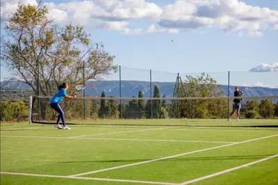 two people playing tennis on a tennis court at Appartement Nature Golf de Saumane - Vue & Calme in Saumane-de-Vaucluse