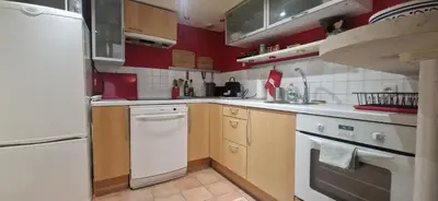 a kitchen with wooden cabinets and a white dishwasher at Loft in hôtel particulier, city-center, air conditioned in Aix-en-Provence