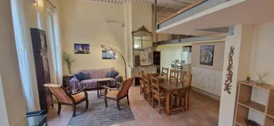 a living room with a couch and a table and chairs at Loft in hôtel particulier, city-center, air conditioned in Aix-en-Provence