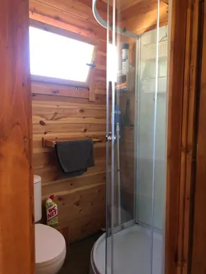 a bathroom with a toilet and a glass shower at Cabane bambou in Apt