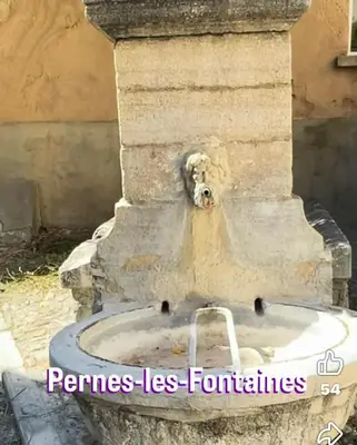 a stone fountain with a water at Cabane bambou in Apt