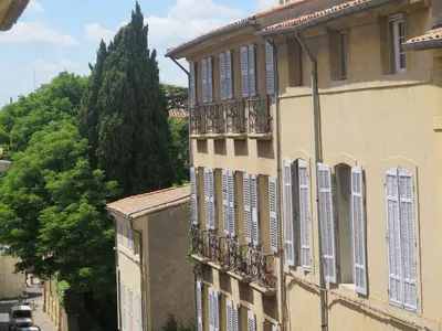 a building with shuttered windows on a city street at Appartement Quartier Mazarin in Aix-en-Provence