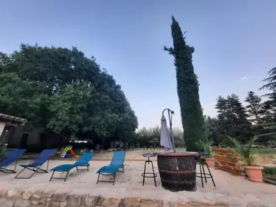 a group of chairs and a table and an umbrella at l'Estagnol in Ansouis