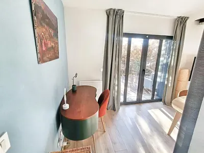 a living room with a table and chairs and a window at Au sommet des Ocres et des Bois - Maison T3 & Parking in Roussillon