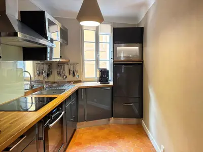 a kitchen with stainless steel appliances and black cabinets at L Appart Aixois in Aix-en-Provence