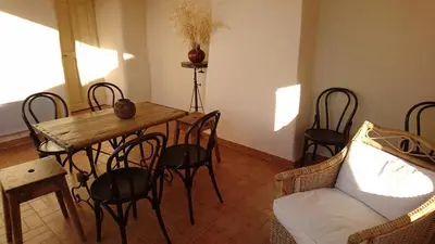 a living room with a table and chairs and a couch at Grande maison de village - solarium et terrasse in Saint-Martin-de-Castillon