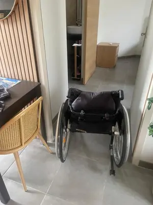 a wheelchair sitting in a hallway next to a table at l'Esquirou in Malemort-du-Comtat