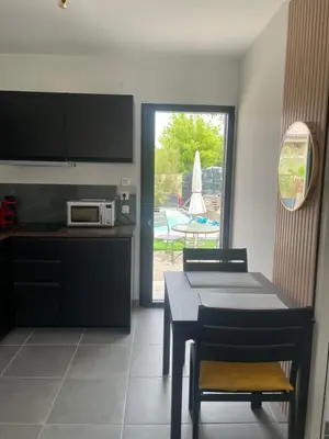 a kitchen with a table and a dining room with a patio at l'Esquirou in Malemort-du-Comtat