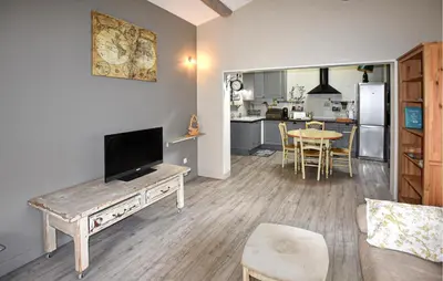 a living room with a tv and a table and a kitchen at Lovely Home In Carpentras With Wifi in Carpentras