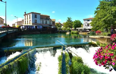 a river with a waterfall in a city at Lovely Home In Carpentras With Wifi in Carpentras
