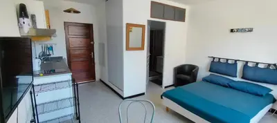 a bedroom with a bed and a kitchen and a sink at GitesLuberon 1 studio in Charleval