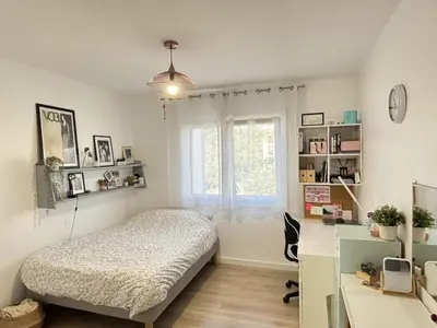 a bedroom with a bed and a desk and a window at Les Cerisiers in Aix-en-Provence