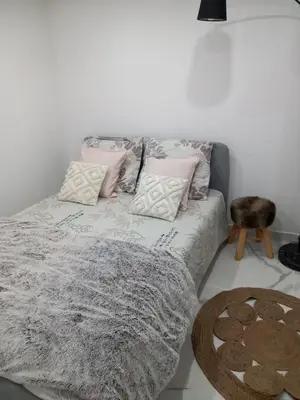 a bed with pillows and a blanket on it at Appartement indépendant dans une villa in Miramas