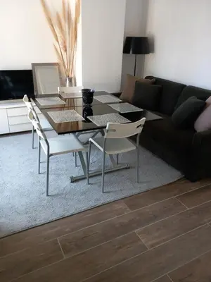a living room with a table and chairs and a couch at Appartement indépendant dans une villa in Miramas