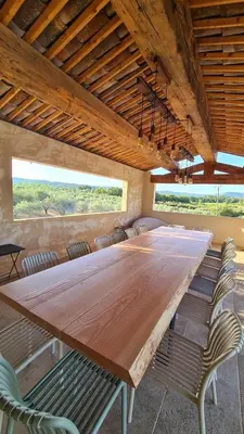 a large wooden table in a room with chairs at Domaine des Hauts de Riganel in La Bastide-des-Jourdans