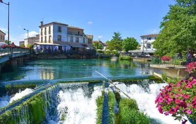 a river with a waterfall in a city with flowers at 2 Bedroom Lovely Home In Vedène in Vedène