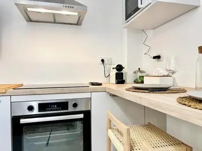a kitchen with a stove top oven next to a counter at Lou Miradou 2 - Vieux village médiéval, Cosy, Clim, 2 personnes in Miramas