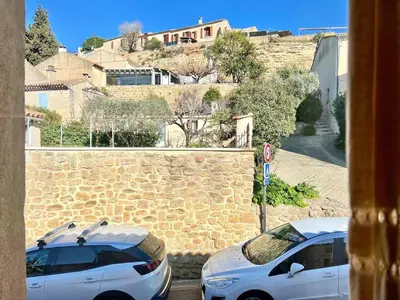 two white cars parked next to a stone wall at Lou Miradou 2 - Vieux village médiéval, Cosy, Clim, 2 personnes in Miramas