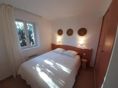 a bedroom with a bed with two pillows and a window at Le Mazet des Jasmins in Gordes