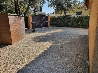 a driveway with a wooden gate and a fence at Chez Mylène et Jean in Bédoin