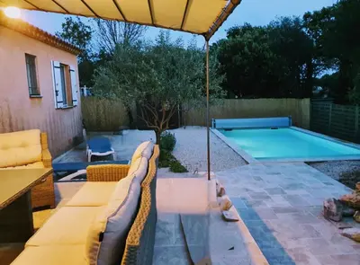 a patio with an umbrella and a swimming pool at Chez Mylène et Jean in Bédoin
