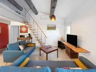 a living room with a blue couch and a tv at Maison provençale de charme au cœur du Luberon in Saint-Saturnin-les-Apt