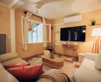 a living room with a couch and a flat screen tv at Villa provençale avec piscine privée et jardin ensoleillé in Mollégès