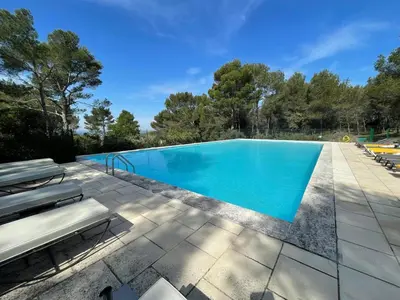a swimming pool with blue water on a patio at Gîte Le Provence Spacieux 100m2 in Saumane-de-Vaucluse