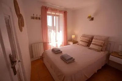 a bedroom with a white bed with towels on it at Maison Valabregue in Robion en Luberon