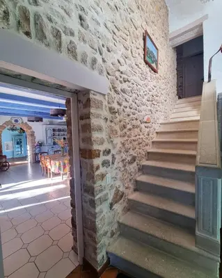 a stone house with a staircase leading to a dining room at Mas Provençal with Swimming Pool & Air Conditioning in Rustrel