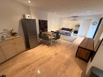 a kitchen and living room with a table and a refrigerator at Maisonnette in Aix-en-Provence