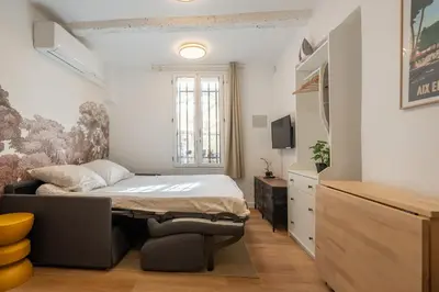 a living room with a couch and a table at Studio Climatisé rdc plein centre in Aix-en-Provence
