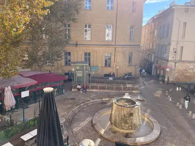 a building with a fountain in the middle of a street at Studio climatisé plein centre ville 1er ETAGE in Aix-en-Provence