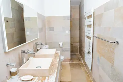a bathroom with two sinks and a toilet at Maison de charme avec piscine chauffée à Gordes in Gordes