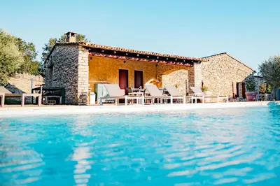 a villa with a swimming pool in front of a house at Maison de charme avec piscine chauffée à Gordes in Gordes