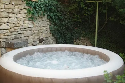 a hot tub in front of a stone wall at Lou pichoun studio au coeur d'un village provençal in Gargas