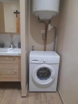 a washing machine in a bathroom with a sink at Gîte La Chouette Hulotte classé 3 étoiles Spa, Mt Ventoux, Parc Spirou in Flassan