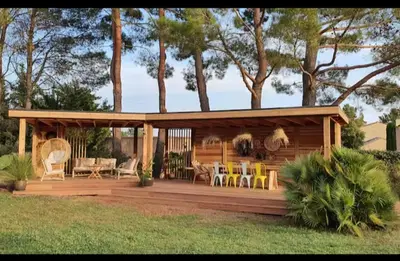 a house with a deck with chairs and tables at Villa 170m2 avec piscine près d Aix en provence 7 couchages in Éguilles