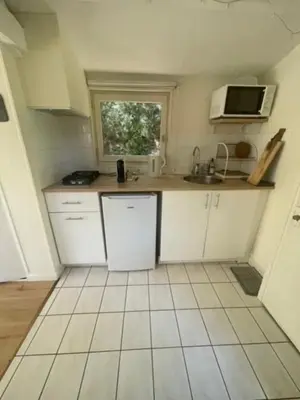 a small kitchen with white cabinets and a microwave at Le Charmeur - Le Chalet Attrape-Coeur in Aix-en-Provence