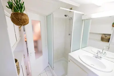 a white bathroom with a sink and a shower at Le Charmeur - Le Chalet Attrape-Coeur in Aix-en-Provence