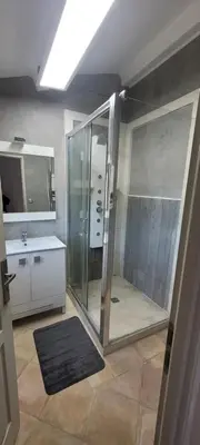a bathroom with a glass shower and a sink at Charming villa with a pool in Cadenet
