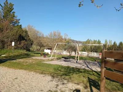 a playground with a swing set in a park at Mobil-Home Provence in Cheval-Blanc