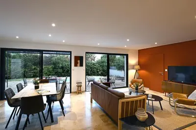 a living room with a couch and a table at La Villa Plein Soleil in LʼIsle-sur-la-Sorgue
