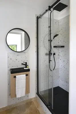 a bathroom with a shower with a sink and a mirror at La Villa Plein Soleil in LʼIsle-sur-la-Sorgue