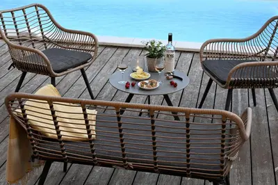 a table and chairs on a deck with a table and drinks at La Villa Plein Soleil in LʼIsle-sur-la-Sorgue