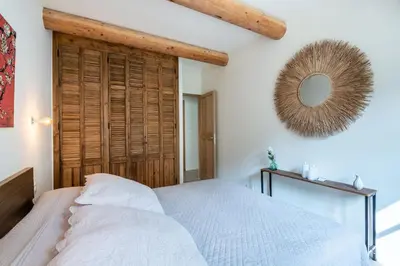 a bedroom with a white bed and a mirror at Mas des Gémeaux in Ménerbes