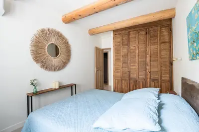 a bedroom with a bed and a mirror on the wall at Mas des Gémeaux in Ménerbes